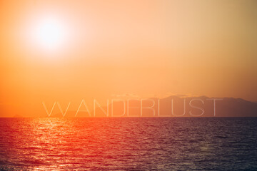 Fototapeta premium Amazing sunset on a seascape, with the word wanderlust text on layer,