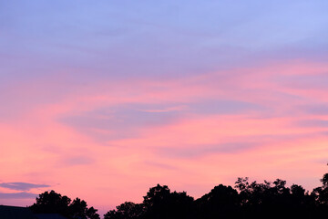 Beautiful twilight sky with clouds after sunset above the trees in summer season