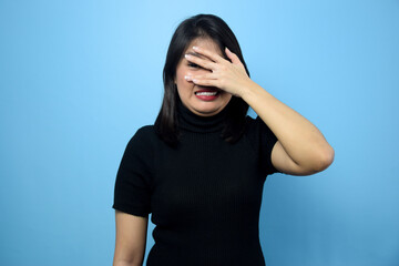 Portrait of Young beautiful asian women wearing black turtle neck shirt with blue isolated background