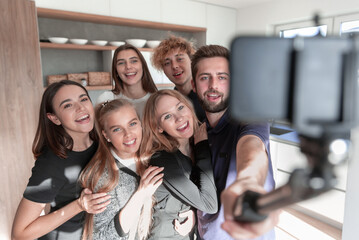 Image of happy young friends at home take a selfie by camera