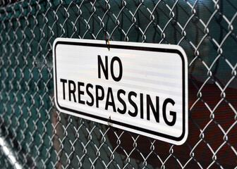 No trespassing sign on chain link fence at construction site