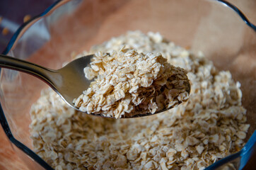 close up on a spoon full of oatmeal over a bowl with the cereal