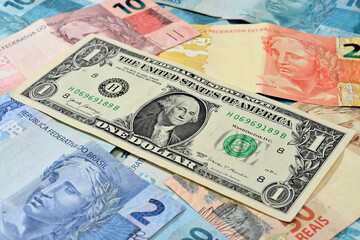 Obraz na płótnie Canvas Nota de 1 dólar junto com reais brasileiros de diversos valores
