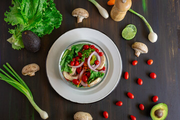 cherry tomato salad, with mushrooms, onion on a black table, with some patterns