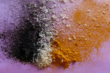 Violet background with colorful close up explosion of ingredients - activated carbon, coconut and...
