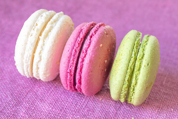 Multi-colored macaroons on a linen napkin. Mcarons or macaroons is French or Italian dessert. Close-up.