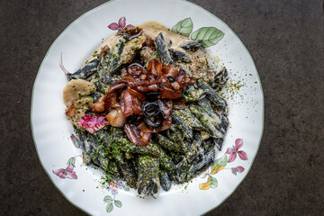 top down view of squid ink penne pasta and onions