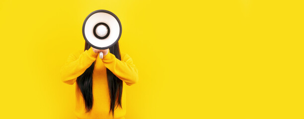 girl in a yellow sweater with a megaphone on a yellow background