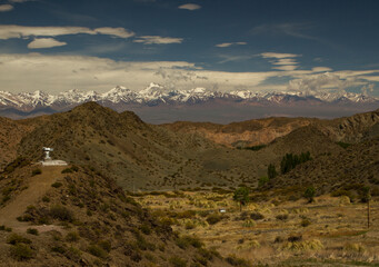 The Andes mountain range. Arid desert valley landscape and the Andes mountains with snowy peaks in the background. Pampa del Leoncito natural reserve, San Juan, Argentina