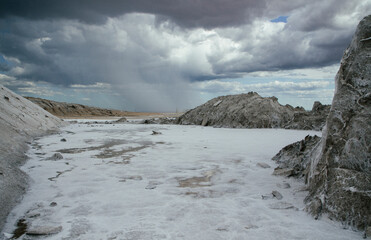 Industrial. Mining. Natural salt flats landscape. Saltworks and fields under a dramatic stormy sky