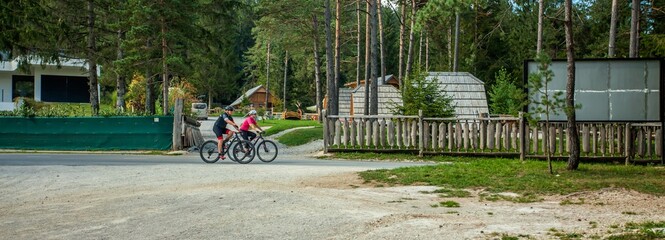 Biker couple biking around a glamping resort at Bloke Lake at Nova Vas, Slovenia