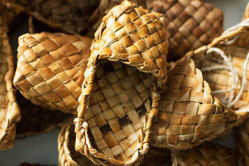 Obraz premium woven shoes made of wood bark from the master on the table