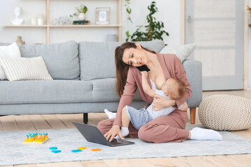Stress of maternity leave. Mother working at home and breastfeeding infant baby