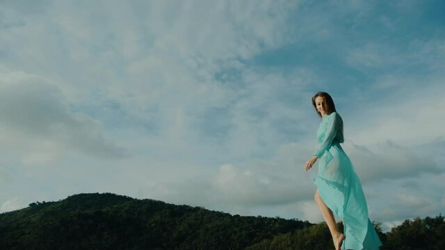 irl in a bikini with nude sexy legs moves against the sky and touches her dress