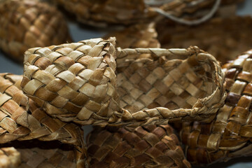 Obraz premium woven shoes made of wood bark from the master on the table