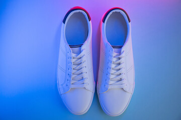 Pair of sneakers on color background, top view