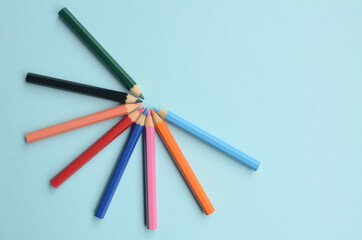 display of the empty space with colored pencils, the concept of colored pencils on a blue background
