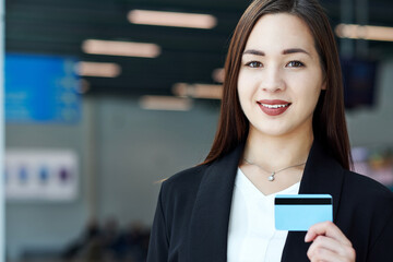 Asian Businesswoman holding a blank credit card. Portrait of beautiful girl in office or meeting room