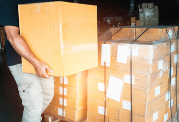 Worker courier lifting shipment boxes, packaging, cardboard box, warehouse delivery service shipping goods at manufacturing warehouse.