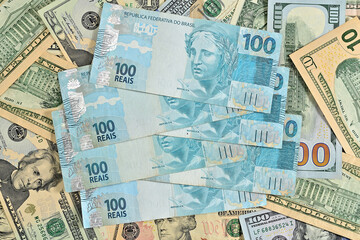 Notas de 100 reais junto com dólares americanos de diversos valores