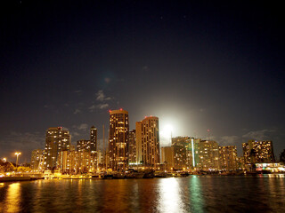 Obraz premium Full Large Moon raises over Waikiki hotels and Marina at Night