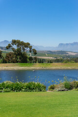 Countryside landscape with pond, lake and green grass