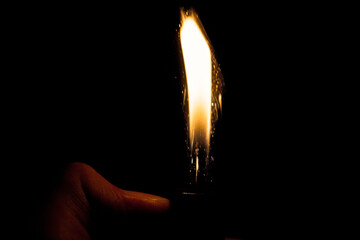 Close up view of real sparking light from lighter in dark black background - obrazy, fototapety, plakaty