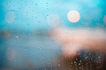 Wet window with water drops and silhouette of airplane on the background