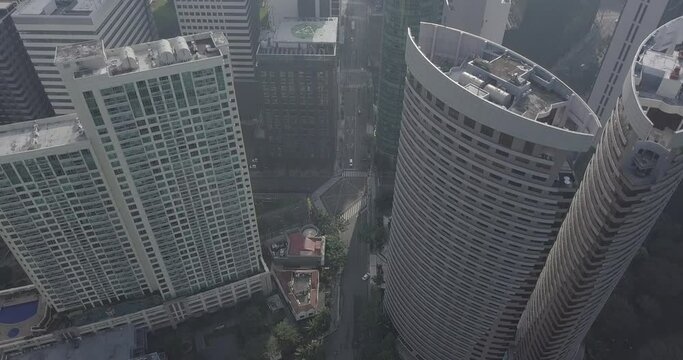 Ungraded, Straight aerial flight above skyscrapers in business district. Tilt up following main avenue's line. City view. Drone, 4K. 