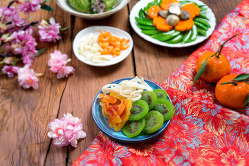 Dried fruit and jam as tradition dessert - Mut Tet on dinning table of Tet holiday or Lunar New Year of Vietnamese or Asian. Beautiful table with blossom flower and other traditional food