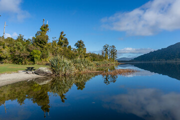 Lake landscape with mountain hills and reflection in still water