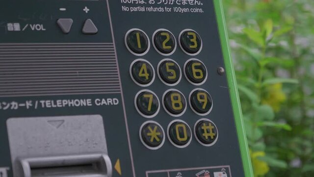 a green public phone in tokyo, japan