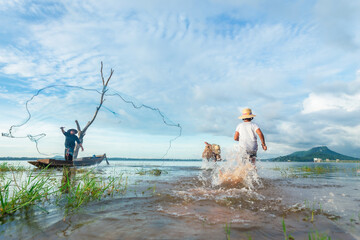 Group of Asian fisherman with catching fish in the early morning. Concepts nature and way of life.
