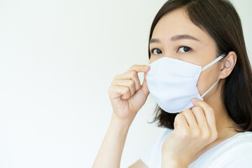 Asian young attractive woman wearing a protective hygiene mask over her face to protect flu and virus. Woman with face mask portrait with copyspace. Covid19 and Coronavirus.