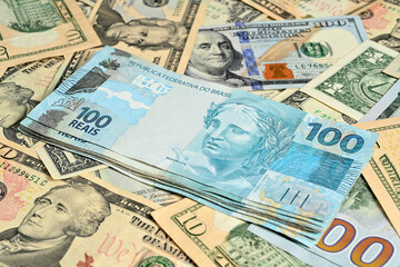 Obraz na płótnie Canvas Notas de 100 reais junto com dólares americanos de diversos valores