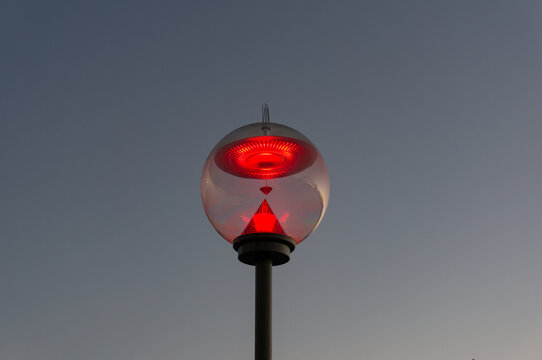 Colorful red gas glass street lamp against blue sky on the background