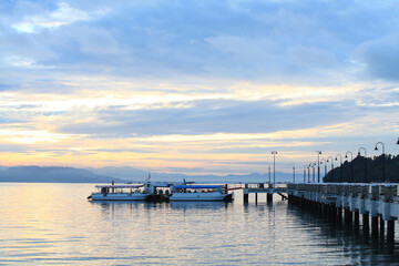 Boat resting near a jetty with sunrise background