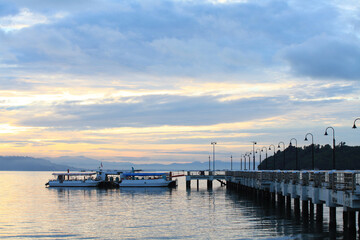 Fototapeta na wymiar Boat resting near a jetty with sunrise background