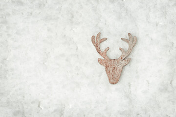 Head and antlers of deer, wooden toy fot christmas tree. Figure of deer on white snow. Christmas decoration. Holiday winter background.