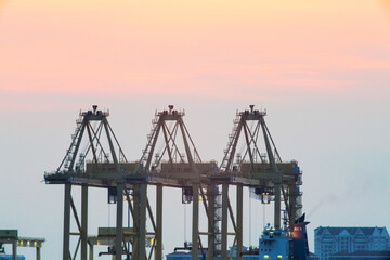 Fototapeta na wymiar Crane for shipping container carrier with sunrise background 