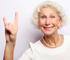 Elderly happy woman giving a thumb up and looking at the camera