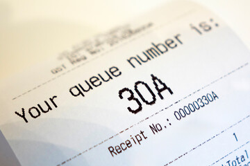 Close up of Coffee Receipt slip with queue number on it.