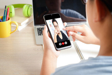 Asian boy learns online with teacher From home via a video call application on a smartphone. Concept, social distance, technology for education