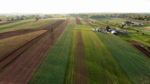 High aerial dolly shot of Lancaster County farmland fields in rural PA, pattern patchwork-like quilt