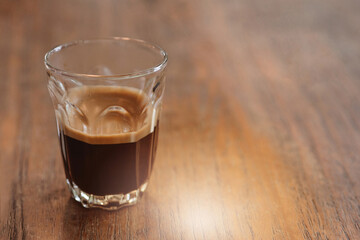 A cup of espresso coffee on wooden table, with copy space