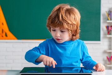School child with tablet in school classroom. Children learning. Kids from primary school.