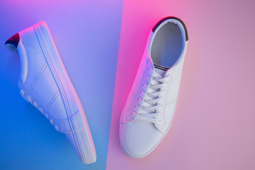 Pair of sneakers on color background, top view