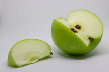 sliced green apple on white
