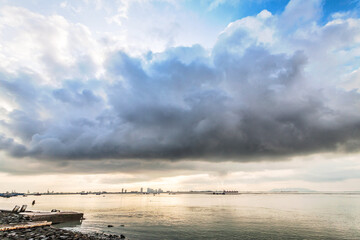 Obraz premium Cloudy storm view by the shore during sunrise