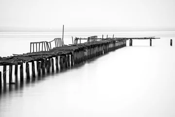 Foto auf Acrylglas Schwarz und weiss Langzeitbelichtung der Holzbrücke im Rücken und weißem Hintergrund